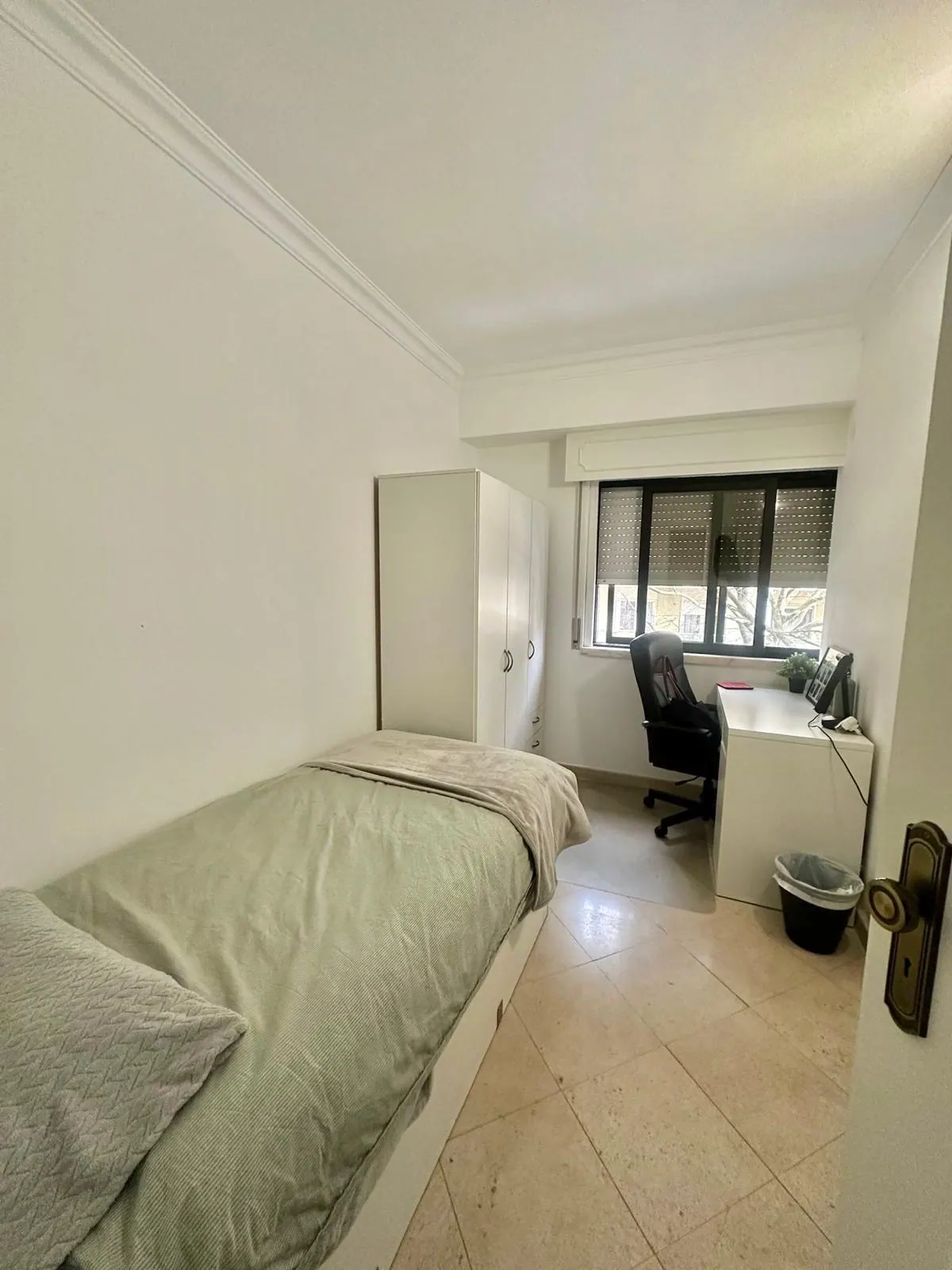 Quarto do T4 com roupeiro e zona de estudo, com janela para a rua
